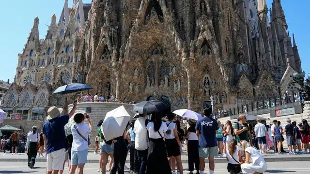 epa10815415 Tourists protect themselves from the sun with umbrellas in Barcelona, Spain, 23 August 2023. The Fabra Observatory has registered the highest minimum temperature in Barcelona’s history on the night from 22 to 23 August with 29,4 degrees Celsius. EPA/ALEJANDRO GARCIA
