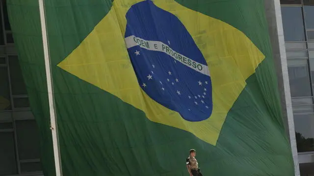 epa10245399 A giant Brazilian national flag placed on the arches of the Palacio do Planalto, in Brasilia, Brazil, 15 October 2022. The Brazilian President Jair Bolsonaro, who aspires to re-election, generated an intense controversy this Friday by extending a gigantic Brazilian flag at the headquarters of the Presidency because it is not only the national symbol but also one of the emblems of his electoral campaign. The far-right leader not only determined that officials of the Presidency itself extend the flag but, in an apparent provocation to his opponents and the electoral justice system, he challenged someone to order the removal of the national symbol from public buildings. EPA/Joedson Alves