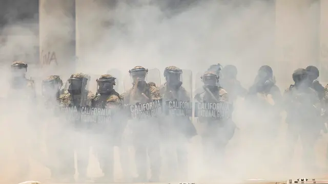 epa12164954 Members of the California National Guard seen through clouds of tear gas in front of the Edward R. Roybal Federal Building in Los Angeles, California, USA, 08 June 2025. US President Donald Trump has deployed approximately 2,000 National Guard troops to Los Angeles, despite not receiving a request from the state of California for any additional assistance, following large protests against ongoing immigration enforcement raids area over the last couple of days. EPA/CAROLINE BREHMAN