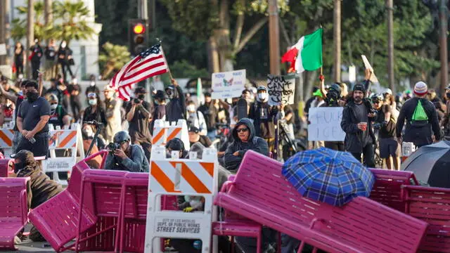 epa12165646 Activists hide behind a makeshift barricade during protests sparked by immigration raids in Los Angeles, California, USA, 08 June 2025. US President Donald Trump has deployed 2,000 National Guard troops, despite not receiving a request from the state of California for any additional assistance, following large protests against ongoing immigration enforcement raids in the Los Angeles area over the last couple of days. EPA/ALLISON DINNER
