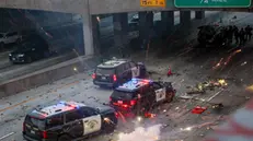 epaselect epa12165691 Police officers take cover as activists shower rocks and fireworks onto their vehicles during protests sparked by immigration raids in Los Angeles, California, USA, 08 June 2025. US President Donald Trump has deployed 2,000 National Guard troops, despite not receiving a request from the state of California for any additional assistance, following large protests against ongoing immigration enforcement raids in the Los Angeles area over the last couple of days. EPA/ALLISON DINNER