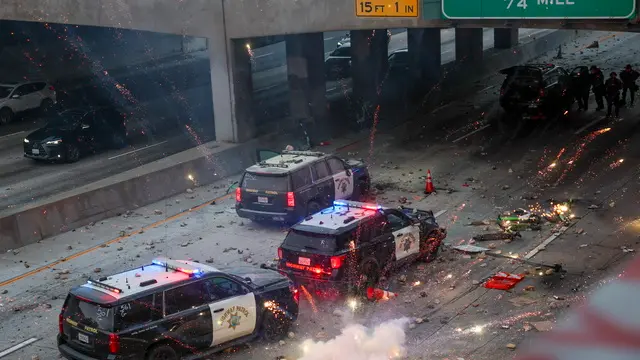 epaselect epa12165691 Police officers take cover as activists shower rocks and fireworks onto their vehicles during protests sparked by immigration raids in Los Angeles, California, USA, 08 June 2025. US President Donald Trump has deployed 2,000 National Guard troops, despite not receiving a request from the state of California for any additional assistance, following large protests against ongoing immigration enforcement raids in the Los Angeles area over the last couple of days. EPA/ALLISON DINNER