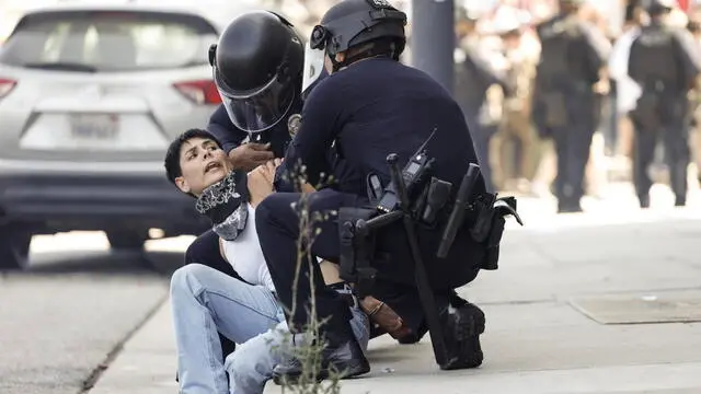 epa12165410 Los Angeles police officers arrest a person during protests near the Edward R. Roybal Federal Building in Los Angeles, California, USA, 08 June 2025. US President Donald Trump has deployed 2,000 National Guard troops, despite not receiving a request from the state of California for any additional assistance, following large protests against ongoing immigration enforcement raids in the Los Angeles area over the last couple of days. EPA/CAROLINE BREHMAN