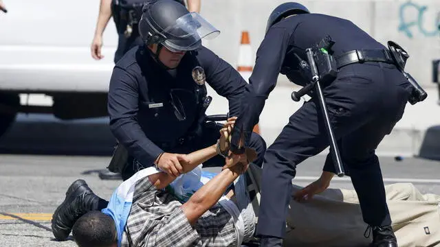 epa12165401 Los Angeles police officers arrest a person during protests near the Edward R. Roybal Federal Building in Los Angeles, California, USA, 08 June 2025. US President Donald Trump has deployed 2,000 National Guard troops, despite not receiving a request from the state of California for any additional assistance, following large protests against ongoing immigration enforcement raids in the Los Angeles area over the last couple of days. EPA/CAROLINE BREHMAN