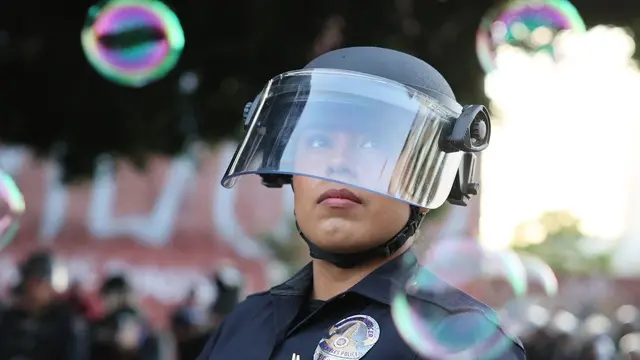 epa12167300 Soap bubbles are in the air around police in riot gear facing off with protesters in Los Angeles, California, USA, 09 June 2025. Approximately 2,000 National Guard troops were deployed on 08 June in Los Angeles by US President Donald Trump, though the state of California had not requested any additional assistance, and protests have continued against the Trump administration's immigration enforcement raids over the last couple of days. EPA/ALLISON DINNER