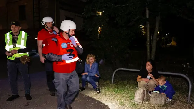epa12169561 Local people speak with medics near the site of a drone strike in Kharkiv, northeastern Ukraine, 11 June 2025, amid the Russian invasion. At least two people were killed and 37 others injured, including five children, after Russian forces launched an overnight attack with drones on Kharkiv and its suburbs, according to the State Emergency Service (SES) of Ukraine. EPA/SERGEY KOZLOV
