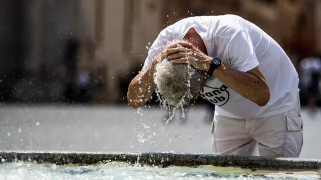 Turisti si rinfrescano dal caldo nella fontana di piazza del Popolo, durante la Fase 3 dell’emergenza per il Covid-19 Coronavirus, Roma, 03 agosto 2020. ANSA/ANGELO CARCONI