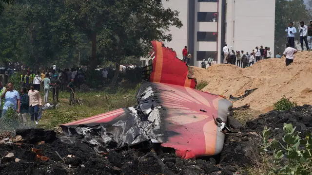 epa12171234 People stand near debris at the site of a plane crash near Sardar Vallabhbhai Patel International Airport in Ahmedabad, Gujarat, western India, 12 June 2025. Air India flight AI171, bound for London carrying 242 passengers and crew members on board a Boeing 787-8 aircraft, crashed minutes after take-off in the Meghaninagar area of Ahmedabad. EPA/SIDDHARAJ SOLANKI