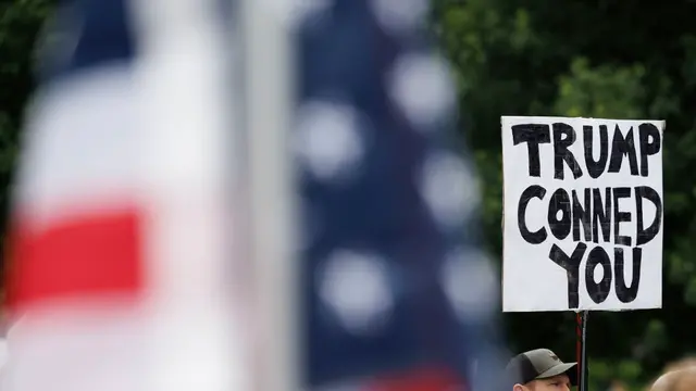 epa12161279 A demonstrator displays a sign that reads 'Trump Conned You,' while taking part in a 'No Kings on D-Day,' rally on the Boston Common, in remembrance of past and present members of the military, in Boston, Massachusetts, USA, 06 June 2025. 06 June 2025 marks the 81st anniversary of the 'D-Day' invasion by allied forces on the beach of Normandy France that lead to the eventual end of World War II. EPA/CJ GUNTHER