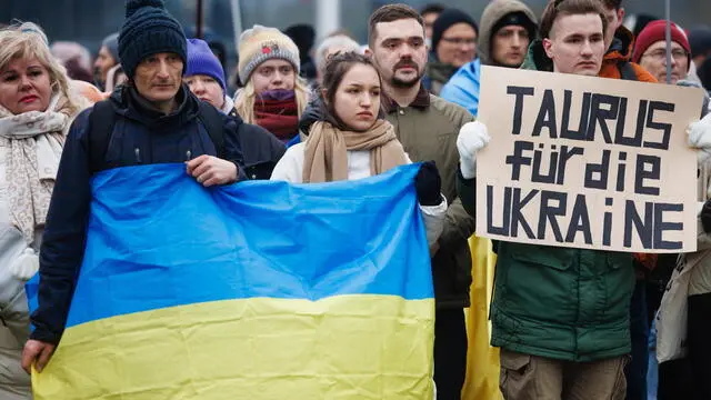 epa11061140 A participant holds a placard reading 'Taurus for Ukraine', asking for delivery of the Taurus cruise missile system to Ukraine, while others display an Ukrainian national flag during a rally to show solidarity with Ukraine in front of the Chancellery in Berlin, Germany, 06 January 2024. Under the motto 'Support Ukraine', the rally held in front of the German Chancellery on 06 January called for more support of Ukraine amid the ongoing Russia-Ukraine conflict. EPA/CLEMENS BILAN