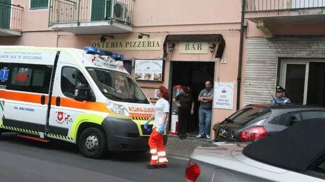 Un'ambulanza davanti alla palazzina dove e' avvenuto l'omicidio-suicidio, Albenga (Savona), 2 giugno 2015. Una donna italiana è stata uccisa a coltellate al culmine di una lite in un appartamento della palazzina e il suo aggressore, l'ex convivente, e' stato trovato privo di vita. Sarebbe stata la donna a ferirlo mortalmente per difendersi durante la colluttazione. L'uomo che l'ha accoltellata è un cittadino nordafricano con il quale la donna non viveva più insieme da cinque mesi. E' stata proprio la figlia di 11 anni a dare l'allarme urlando dal balcone di casa e richiamando così l'attenzione di alcuni passanti che hanno avvertito il 112. Quando i carabinieri sono arrivati sul posto hanno trovato l'uomo agonizzante. La donna era vittima da tempo di episodi di stalking: in una occasione l'ex la aveva attesa sul posto di lavoro tanto che i colleghi la scortavano fin sotto casa. ANSA/ GIO' BARBERA