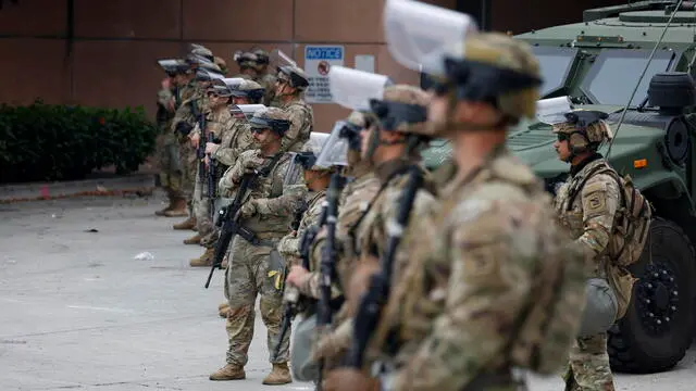 epa12164378 Members of the National Guard stand guard in front of the Federal building in Los Angeles, California, USA, 08 June 2025. Some 2,000 National Guard troops have been deployed by US President Donald Trump to handle the protests over the last couple of days against immigration enforcement raids in the Los Angeles area. EPA/CAROLINE BREHMAN