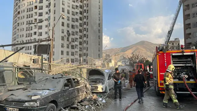 epa12172720 Fire fighters work outside a building that was hit by Israeli air strikes north of Tehran, Iran, 13 June 2025. Israel confirms it has launched strikes on Iran's 'nuclear program' as blasts are heard across the country. The strikes are part of Operation Rising Lion, Israel's Prime Minister Benjamin Netanyahu said, adding Iran was a threat to "Israel's very survival". EPA/ABEDIN TAHERKENAREH