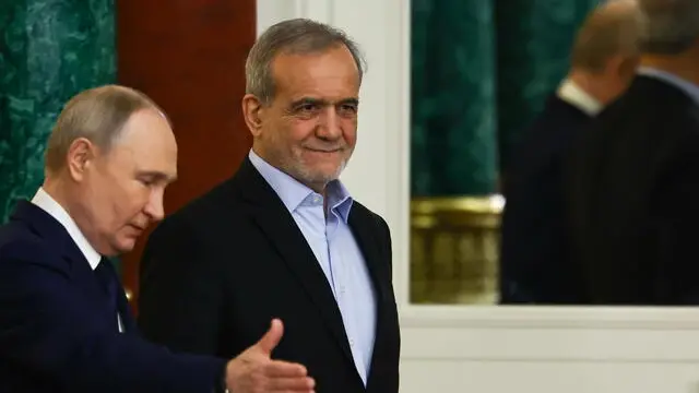 epa11831212 Russian President Vladimir Putin (L) gestures next to Iranian President Masoud Pezeshkian as they attend a documents signing ceremony in Moscow, Russia, 17 January 2025. The Iranian president is on an official visit to Moscow, where he is expected to hold talks with his Russian counterpart Putin and sign an agreement on comprehensive strategic partnership. EPA/EVGENIA NOVOZHENINA / POOL