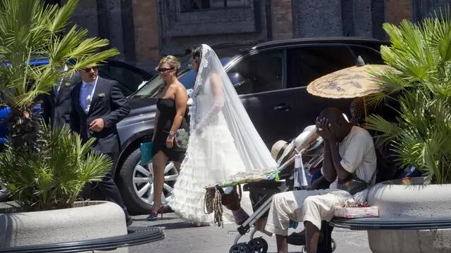 Un venditore di ombrelli di carta si ripara dal sole a Napoli, 07 luglio 2012, sotto la canicola alimentata dalla prepotente avanzata di Minosse, il terzo anticiclone subtropicale sahariano dell'estate che punterà direttamente alla Sardegna, alla Sicilia e poi al Sud, promettendo caldo record su queste regioni fino a meta' Luglio. ANSA / CIRO FUSCO