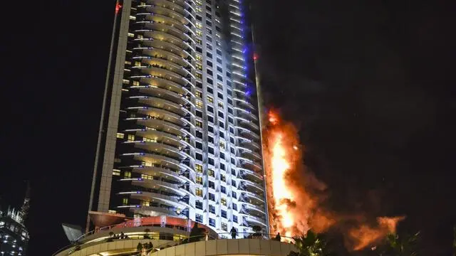 epaselect epa05084825 Flames and smoke after a fire broke out at The Address Hotel in Dubai, UAE. 31 December 2015. Media reports state that there is no immediate news of casualties. EPA/STRINGER