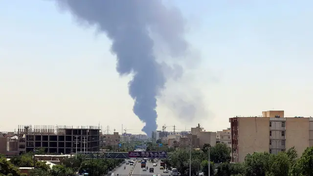 epa12176952 Smoke from an oil refinery rises over residential buildings in southern Tehran, Iran, 15 June 2025. Israel continued to target sites related to Iran's nuclear program and energy facilities, after launching strikes across Iran since 13 June. In retaliation, Iran launched waves of missiles and drones toward Israel. EPA/ABEDIN TAHERKENAREH