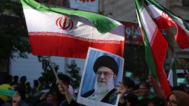 epa12175390 An Iranian woman holds a poster of Iranian supreme leader Ayatollah Ali Khamenei during an anti-Israel rally in Tehran, Iran, 14 June 2025. Israel confirms it has launched strikes on Iran's 'nuclear program' as blasts are heard across the country. Israel launched strikes on Iran's nuclear and military facilities on 13 June, targeting top generals and scientists. In retaliation, Iran launched waves of missiles and drones toward Israel. EPA/ABEDIN TAHERKENAREH