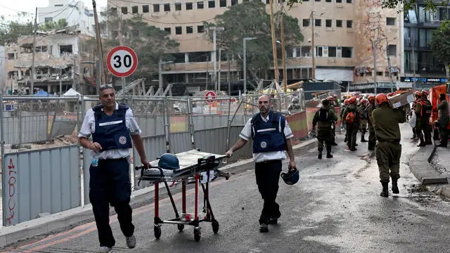 epa12178327 Israeli rescue teams and medical personnel gather at the scene where Iranian ballistic missiles struck buildings in Tel Aviv, Israel, 16 June 2025. According to emergency service, Magen David Adom (MDA), paramedics have pronounced the death of four people and provided medical care to a total of 81 injured, one in serious condition and five in moderate condition. EPA/ATEF SAFADI