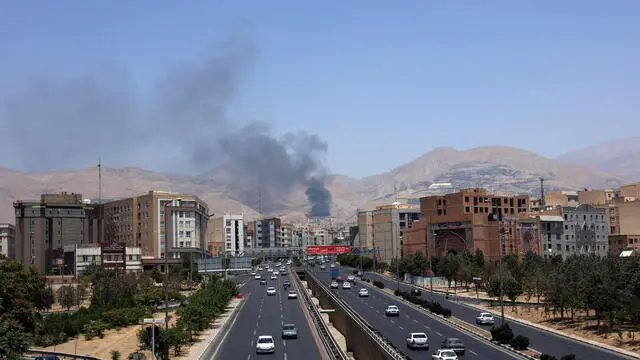 epa12178550 Cars drive along a motorway as smoke rises in the background from an oil refinery, northwest of Tehran, Iran, 16 June 2025. Israel and Iran have been exchanging fire since Israel launched strikes across Iran on 13 June 2025 as part of Operation 'Rising Lion.' EPA/ABEDIN TAHERKENAREH