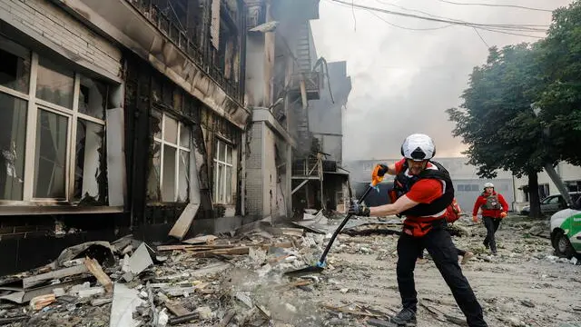 epa12167537 Ukrainian rescuers clean the road for a fire engine at the site of a drone strike following an overnight attack in Kyiv, Ukraine, 10 June 2025, amid the ongoing Russian invasion. At least two people were killed and a dozen more injured after Russia launched a large-scale combined assault across Ukraine, according to the State Emergency Service (SES). EPA/SERGEY DOLZHENKO