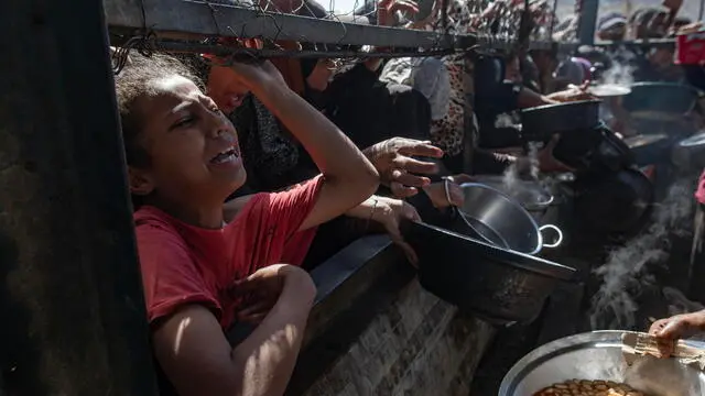 epa12144626 Internally displaced Palestinians gather outside a charity kitchen to receive limited rations amid a shortage of food, in Khan Younis, southern Gaza Strip, 30 May 2025. The United Nations has warned that "the entire population of Gaza is facing the risk of famine" since Israel closed border crossings on 02 March 2025, preventing the entry of essential supplies. The Gaza Government Media Office reported on 24 May that at least 58 people died due to malnutrition, and nearly 250 others due to a lack of food and medicine. EPA/HAITHAM IMAD
