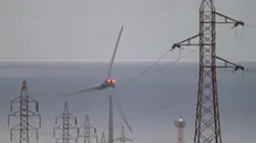 epa12062143 High voltage power lines and a wind turbine on Fuerteventura Island, Canary Islands, southwestern Spain, 29 April 2025. The massive power outage that affected the Iberian peninsula a day earlier did not affect the Canary Islands. A power blackout hit large parts of Spain and spread to neighboring Portugal and France on 28 April, disrupting transport systems, internet connections, and daily life, according to authorities. The exact cause of the outage is unknown. EPA/CARLOS DE SAA