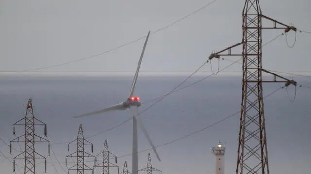 epa12062143 High voltage power lines and a wind turbine on Fuerteventura Island, Canary Islands, southwestern Spain, 29 April 2025. The massive power outage that affected the Iberian peninsula a day earlier did not affect the Canary Islands. A power blackout hit large parts of Spain and spread to neighboring Portugal and France on 28 April, disrupting transport systems, internet connections, and daily life, according to authorities. The exact cause of the outage is unknown. EPA/CARLOS DE SAA
