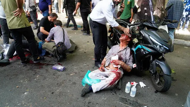 epa12177681 People help the wounded following an Israel airstrike in central Tehran, Iran, 15 June 2025. Israel and Iran have been exchanging fire since Israel attacked Iran on 13 June 2025 as part of operation 'Rising Lion'. EPA/AMIR KHOLOUSI