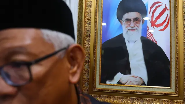 epa12180677 A man stands near the picture of Iran's Supreme Leader Ali Khamenei during an event in solidarity with the people of Iran, at the Iranian embassy in Kuala Lumpur, Malaysia, 17 June 2025, amid recent military escalations between Israel and Iran. EPA/FAZRY ISMAIL
