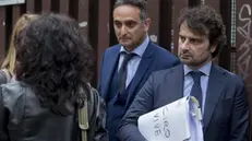 Il faldone degli avvocati Sergio Pisani (d) e Damiano De Rosa (s) con la scritta "Ciro vive" all'esterno del tribunale di piazzale Clodio a Roma, a margine dell'udienza a carico di Daniele De Santis, 28 aprile 2015. ANSA/CLAUDIO PERI