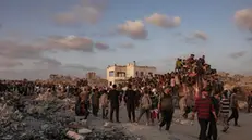 epa12181901 Displaced Palestinians carry bags of flour along Rashid Street in western Jabalia, 17 June, 2025, after humanitarian aid trucks entered the northern Gaza Strip through the Israeli-controlled Zikim crossing, northwest of Gaza City. EPA/HAITHAM IMAD