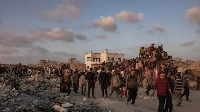 epa12181901 Displaced Palestinians carry bags of flour along Rashid Street in western Jabalia, 17 June, 2025, after humanitarian aid trucks entered the northern Gaza Strip through the Israeli-controlled Zikim crossing, northwest of Gaza City. EPA/HAITHAM IMAD