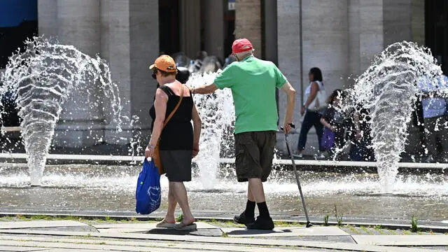 Due anziani in giro per la citta' nonostante il grande caldo di questi giorni. Alcuni cercano refrigerio nelle fontane di piazza De Ferrari. Genova, 17 luglio 2024. ANSA/LUCA ZENNARO (caldo, anziani)