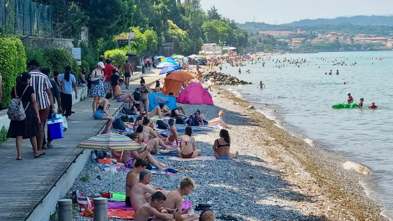 Turisti e residenti affollano una delle spiagge del Basso Garda