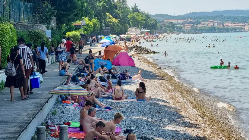 Turisti e residenti affollano una delle spiagge del Basso Garda