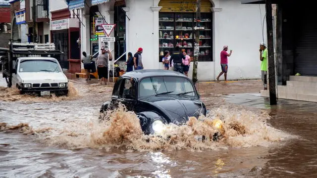 epa12186539 Vehicles travel through a flooded street in Juchitán, Mexico, 19 June 2025. Hurricane Erick, the first of the 2025 season in the Mexican Pacific, made landfall as a Category 3 hurricane and weakened to a tropical storm after passing through the state of Guerrero, in southern Mexico, causing material damage but no casualties. EPA/LUIS VILLALOBOS