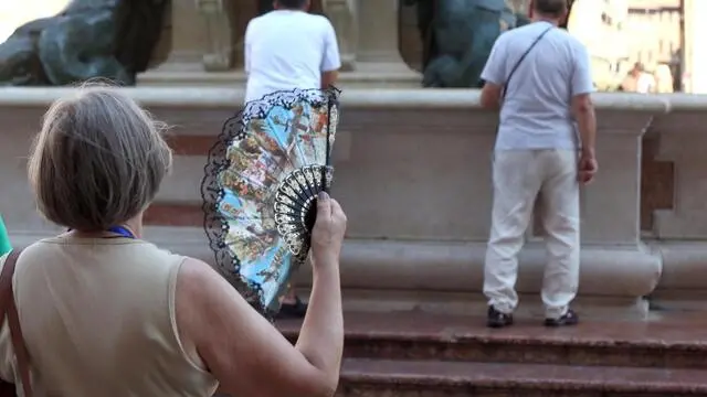 Turisti e cittadini in cerca di refrigerio in piazza Maggiore, Bologna, 31 luglio 2018. La settimana in corso sara' la più calda dall'inizio dell'estate, con tanta afa e temperature che sfioreranno i 40 gradi. L'intensa ondata di caldo avvolgerà tutta Italia, almeno fino al primo weekend di agosto, ma la canicola si farà sentire soprattutto nelle città facendo scattare i bollini rossi in quelle più roventi: mercoledì saranno ben 8 le città italiane contrassegnate con il bollino rosso. ANSA/GIORGIO BENVENUTI