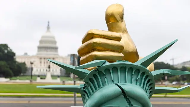 epa12183260 A work of political art titled 'Dictator Approved' on the National Mall in Washington, DC, USA, 18 June 2025. The statue of an unknown artist depicts a golden fist smashing the head of the Statue of Liberty, and includes plaques with quotes from Russian President Vladimir Putin, Hungarian Prime Minister Viktor Orban and North Korean Supreme Leader Kim Jong Un. EPA/JIM LO SCALZO