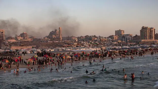 epaselect epa12188037 Smoke rises in the background as internally displaced Palestinians gather on a beach at sunset in Gaza City, 20 June 2025. More than 55,700 Palestinians have been killed in the Gaza Strip, according to the Palestinian Ministry of Health, since Israel launched a military campaign in the strip in response to a cross-border attack led by the Palestinian militant group Hamas on 07 October 2023. EPA/HAITHAM IMAD