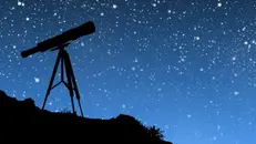 Un telescopio con le stelle cadenti
