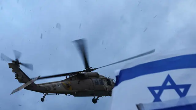 epa11916000 People wave the Israeli flag as a military helicopter transporting freed Israeli hostage Omer Wenkert prepares for landing at Beilinson Hospital Rabin Medical Center in Petah Tikva, Israel, 22 February 2025. Six Israeli hostages were released on 22 February, after being handed over by Hamas to the Red Cross in Gaza as part of the first phase of the Israel-Hamas ceasefire deal. EPA/ATEF SAFADI