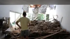 epa12190555 An Israeli resident inspects his damaged living room following an Iranian missile strike on a residential building complex in Tel Aviv, Israel, 22 June 2025. Israel and Iran have been exchanging fire since Israel launched strikes across Iran on 13 June 2025 as part of Operation 'Rising Lion.' EPA/ABIR SULTAN
