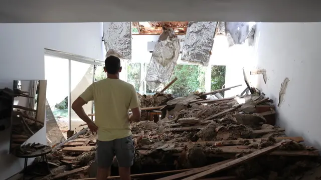 epa12190555 An Israeli resident inspects his damaged living room following an Iranian missile strike on a residential building complex in Tel Aviv, Israel, 22 June 2025. Israel and Iran have been exchanging fire since Israel launched strikes across Iran on 13 June 2025 as part of Operation 'Rising Lion.' EPA/ABIR SULTAN