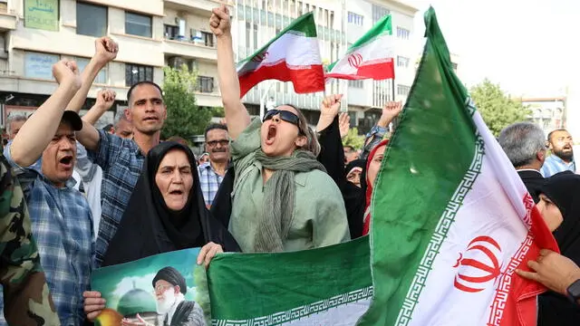 epa12191079 Iranians hold national flags and a placard depicting Iran's Supreme Leader Ayatollah Ali Khamenei (L) during an anti-US and anti-Israel demonstration in Tehran, Iran, 22 June 2025. The US Department of Defense announced on 22 June, that the US Central Command conducted overnight strikes against three nuclear facilities in Iran. These US strikes come as Israel has been conducting its campaign across Iran since 13 June, targeting nuclear, military, and energy facilities, prompting Iran to launch retaliatory waves of missiles and drones toward Israel. EPA/ABEDIN TAHERKENAREH