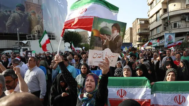 epa12191109 An Iranian woman waves a national flag and holds up a placard depicting Iran's Supreme Leader Ayatollah Ali Khamenei during an anti-US and anti-Israel demonstration in Tehran, Iran, 22 June 2025. The US Department of Defense announced on 22 June, that the US Central Command conducted overnight strikes against three nuclear facilities in Iran. These US strikes come as Israel has been conducting its campaign across Iran since 13 June, targeting nuclear, military, and energy facilities, prompting Iran to launch retaliatory waves of missiles and drones toward Israel. EPA/ABEDIN TAHERKENAREH