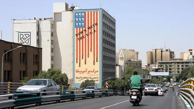 epa12190531 Traffic passes by a building displaying an anti-US mural in Tehran, Iran, 22 June 2025. The US forces struck three of Iran's key nuclear sites: Natanz, Isfahan and Fordo, US President Trump announced on 21 June. Israel and Iran have been exchanging fire since Israel launched strikes across Iran on 13 June 2025 as part of Operation 'Rising Lion.' EPA/ABEDIN TAHERKENAREH