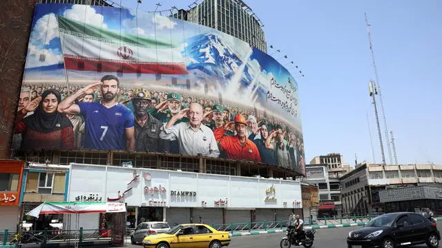 epa12190536 The traffic passes a billboard showing various Iranians including military personnel and Iranian Foreign Minister Abbas Araghchi (3-R) saluting and a message reading 'We all are soldiers of Iran' at Vali-Asr square in Tehran, Iran, 22 June 2025. The US forces struck three of Iran's key nuclear sites: Natanz, Isfahan and Fordo, US President Trump announced on 21 June. Israel and Iran have been exchanging fire since Israel launched strikes across Iran on 13 June 2025 as part of Operation 'Rising Lion.' EPA/ABEDIN TAHERKENAREH