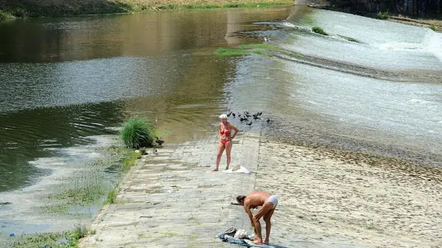 Alcune persone prendono il sole sul greto dell'Arno a Firenze, 18 luglio 2013. Nel capoluogo toscano la temperatura massima è stata oggi di 33,7 gradi. ANSA/CARLO FERRARO