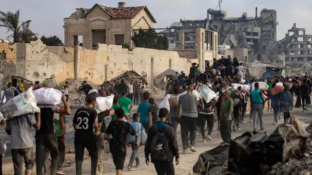 epa12191497 Displaced Palestinians carry relief packages along Rashid Street, west of Jabalia, 22 June 2025, after humanitarian aid trucks entered the northern Gaza Strip through the Israeli-controlled Zikim crossing, northwest of Gaza City. More than 55,700 Palestinians have been killed in the Gaza Strip, according to the Palestinian Ministry of Health, since Israel launched a military campaign in the strip in response to a cross-border attack led by the Palestinian militant group Hamas on 07 October 2023. EPA/HAITHAM IMAD